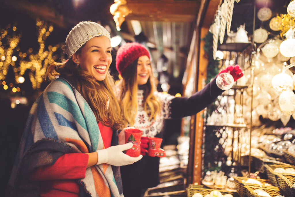Vrouwen genieten van een kerstmarktkraam